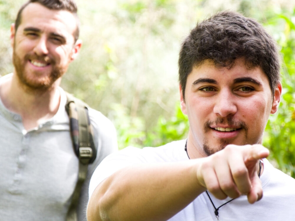 Two men hiking and one pointing to the trail ahead